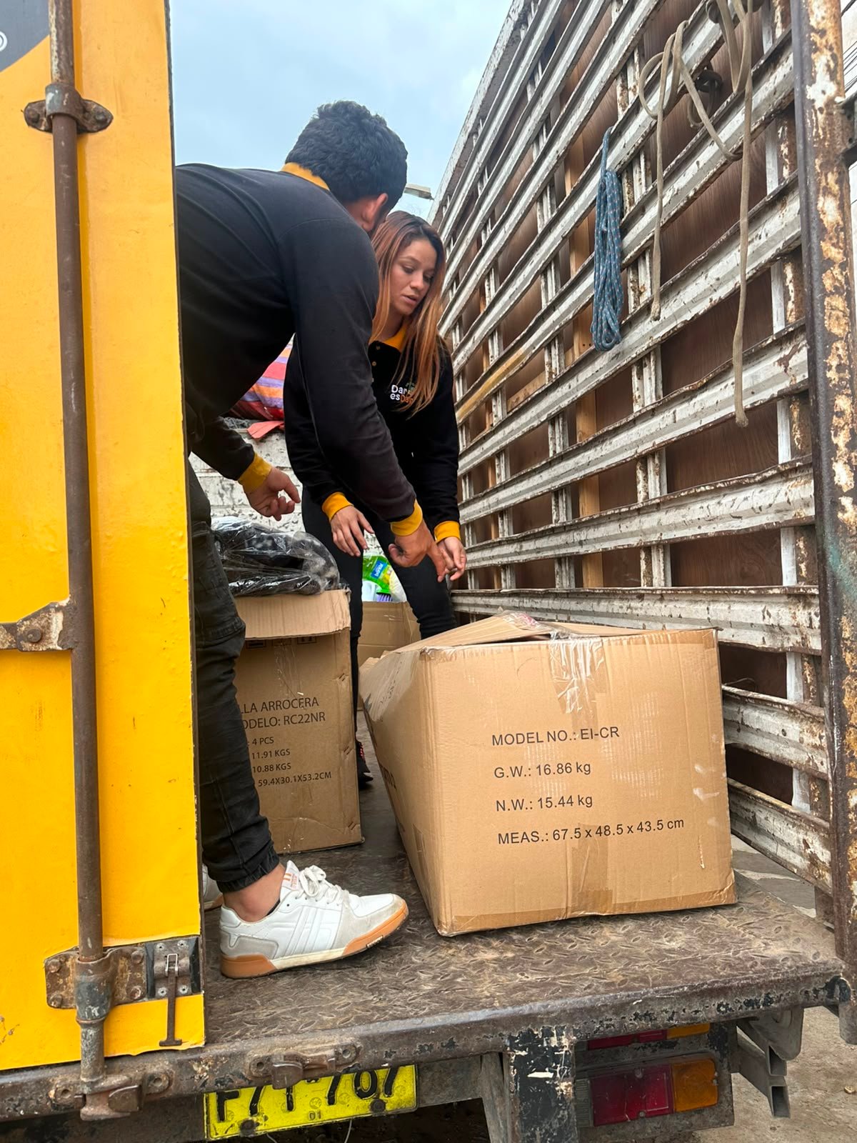 Voluntarios cargan cajas de donaciones en el camión